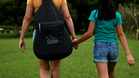 Mujer-Y-Niña-Caminando-Sobre-La-Hierba